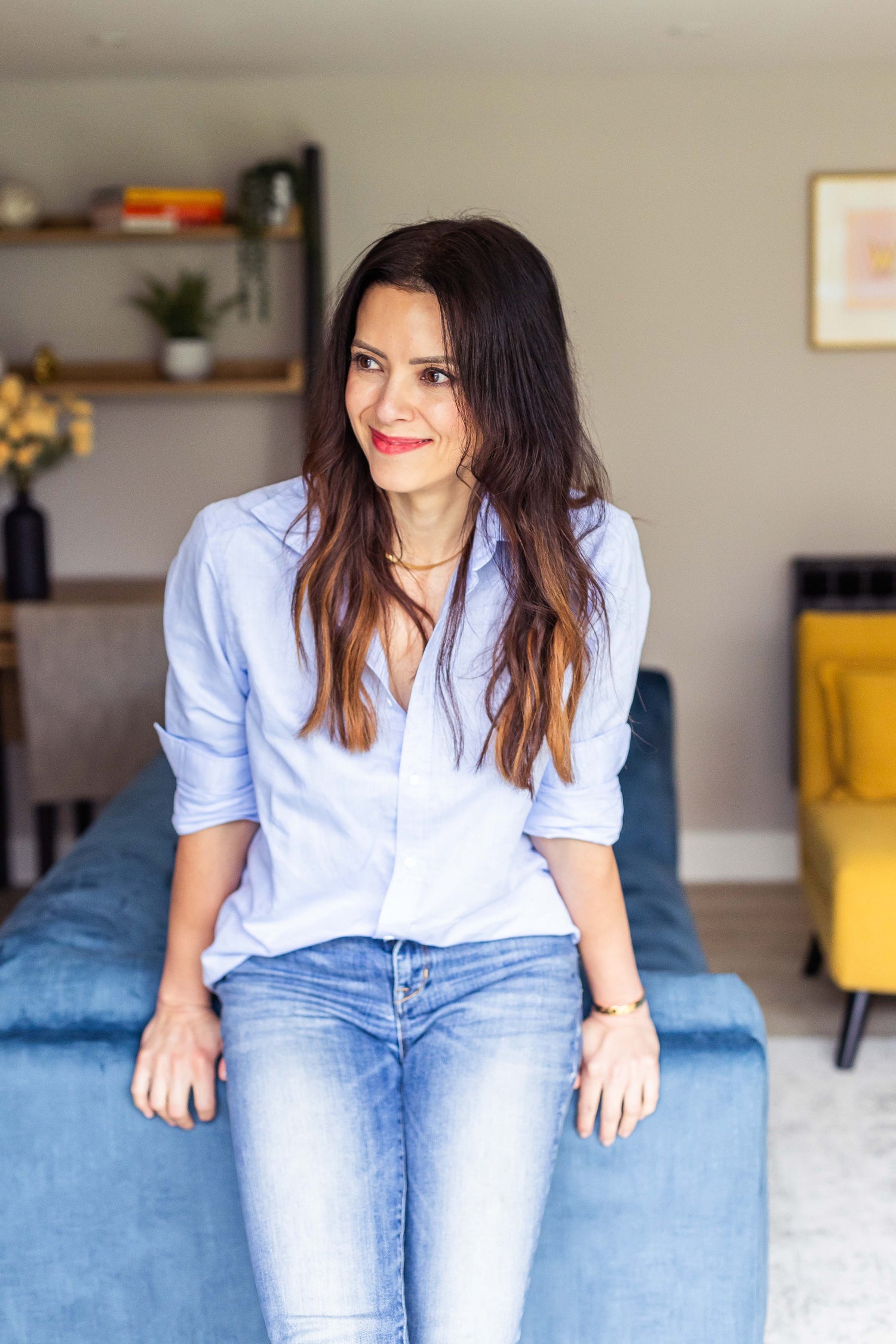Woman sitting on a blue couch in a living room setting